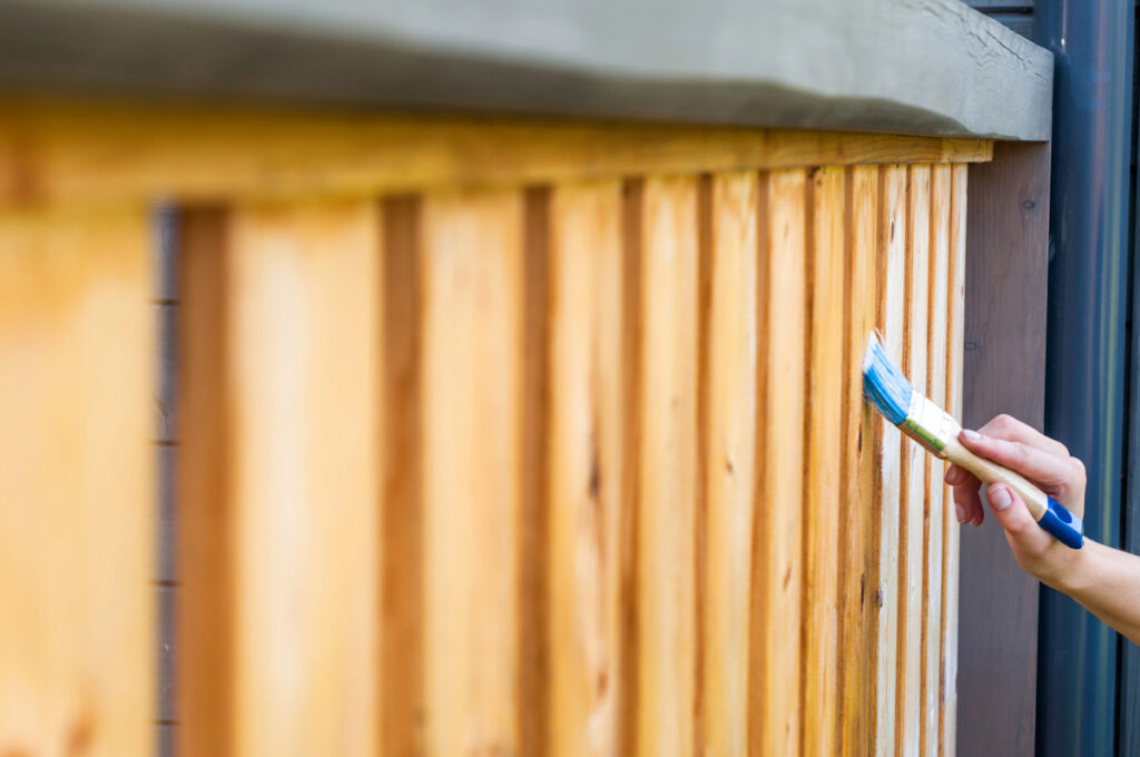 applying varnish to summer house railings