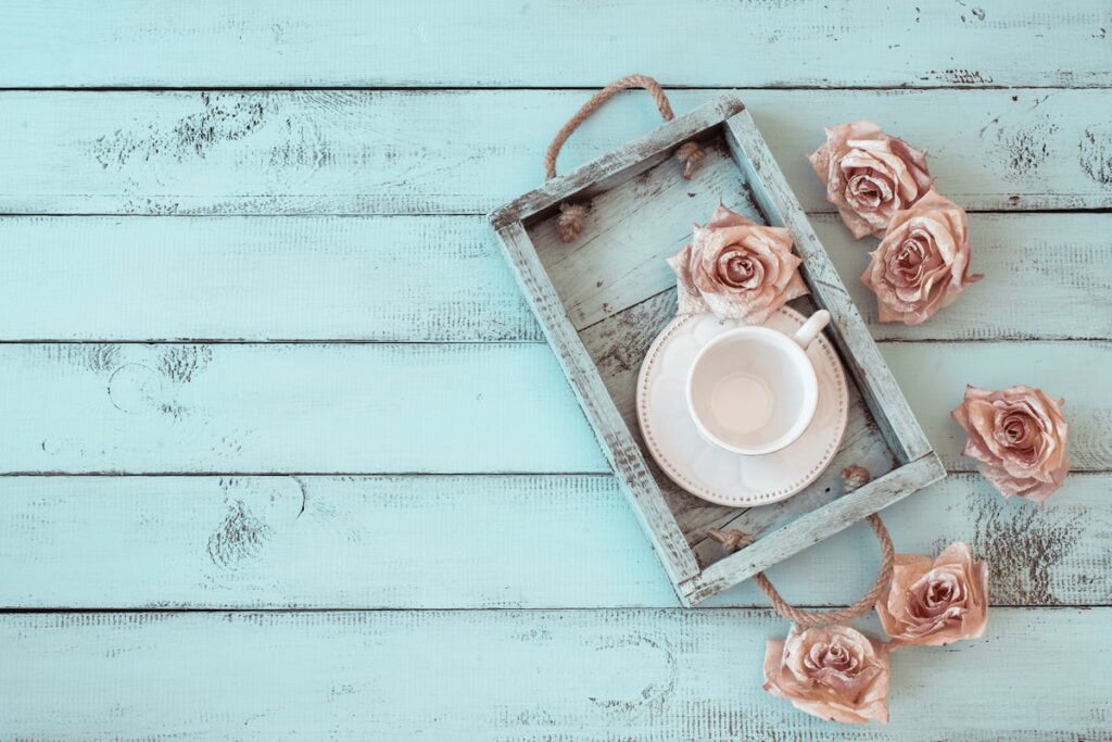 shabby chic concept weathered tray and roses on a wooden table