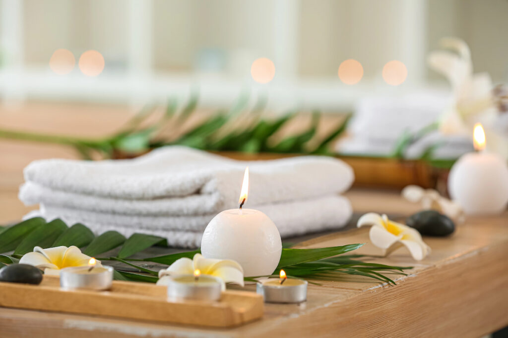 wellness concept candles flowers towels on table