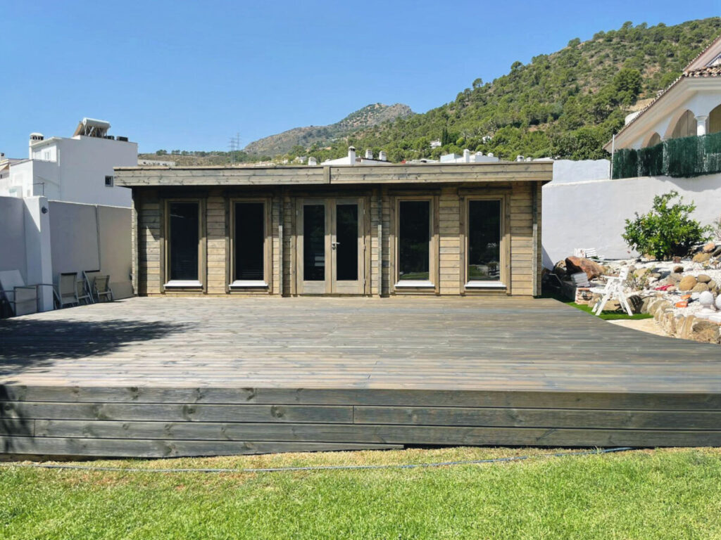 front view of a wooden garden room with a terrace